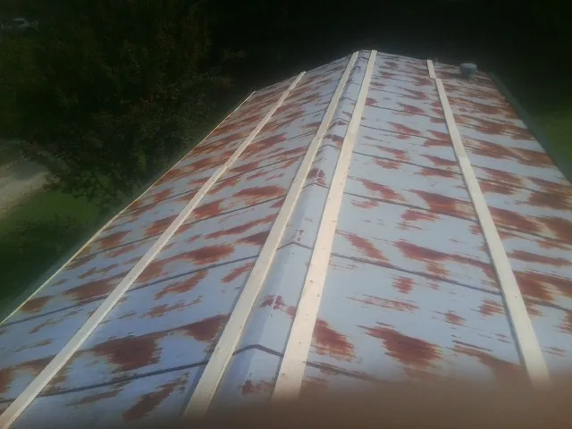 Rusted metal roof panels with new wood purlins before replacement — Storm Damage Roof Repair in Maurice by Roofing Brothers