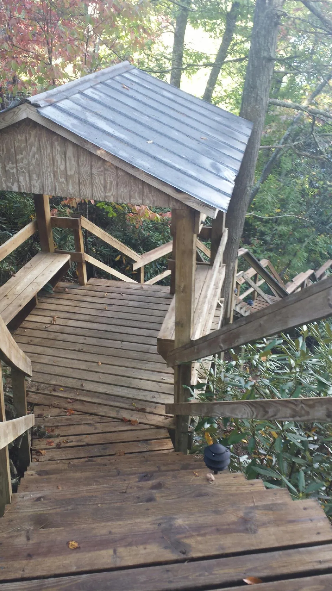 Metal roofed shelter over wooden steps on a wooded walkway — Skylight Repair & Installation work by our crew in Maurice