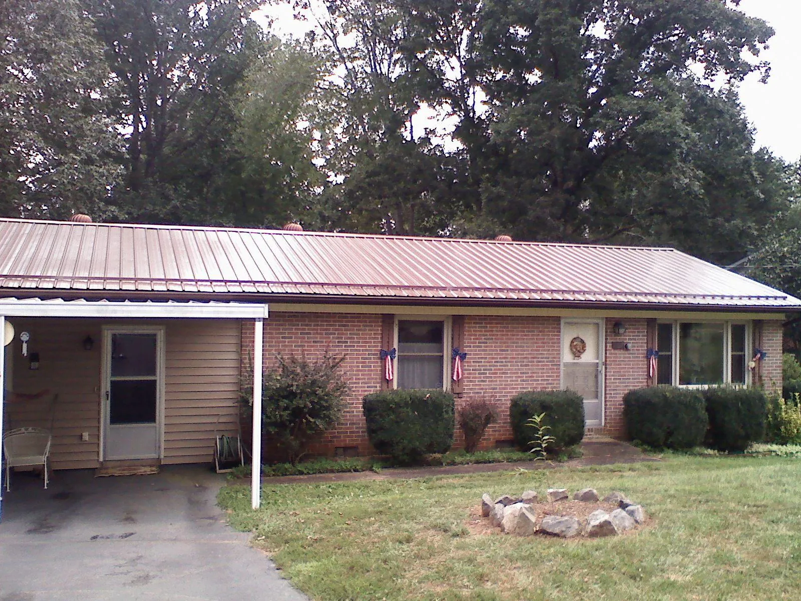 Bronze metal roof and carport on a brick ranch home — Roof Repair work by our crew in Maurice